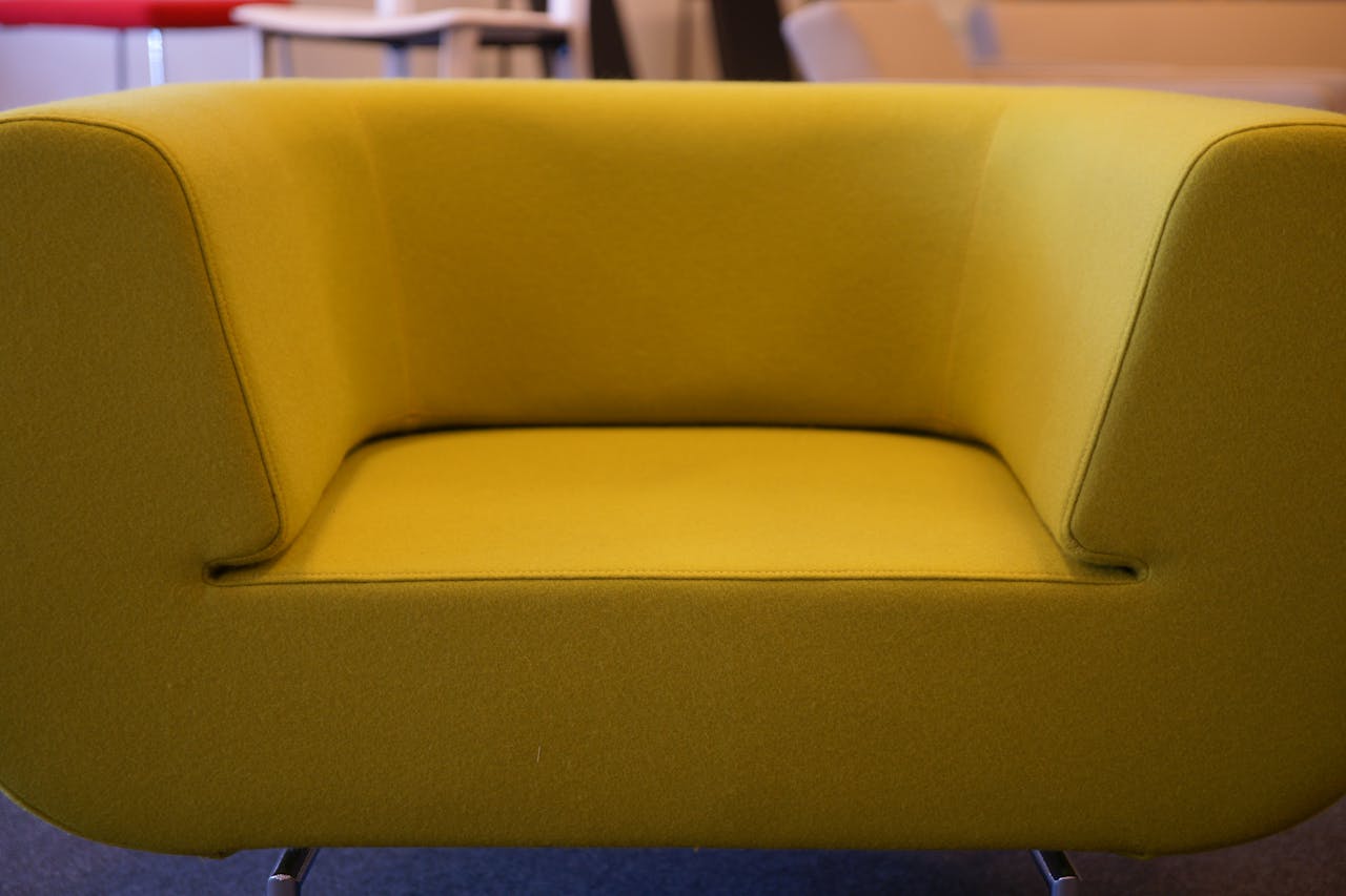 Capture the elegance of a trendy mustard yellow armchair in a modern interior design setting.